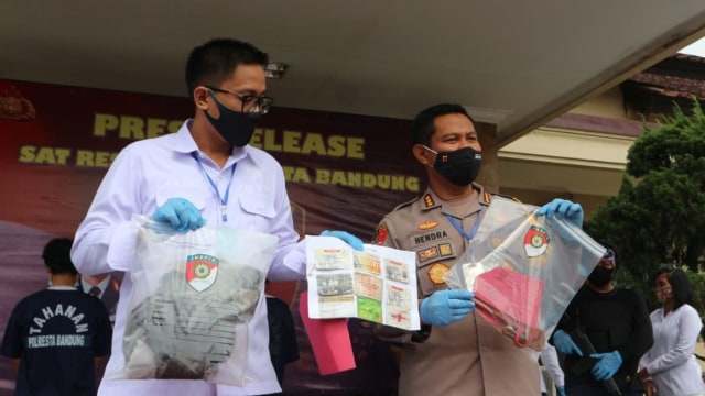 Police in Bandung holding up evidence in the alleged murder of a 61-year-old rideshare driver in the hands of four young women. Photo: Bandung Police