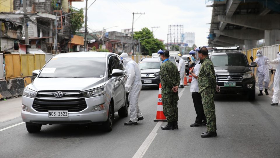 Cops and a medical worker inspect a car at a checkpoint. Photo: Philippine National Police/FB
