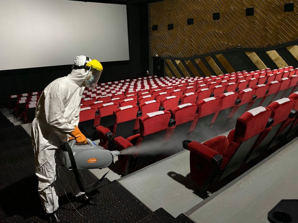 A health worker sprays disinfectant inside a cinema of MVP chain.