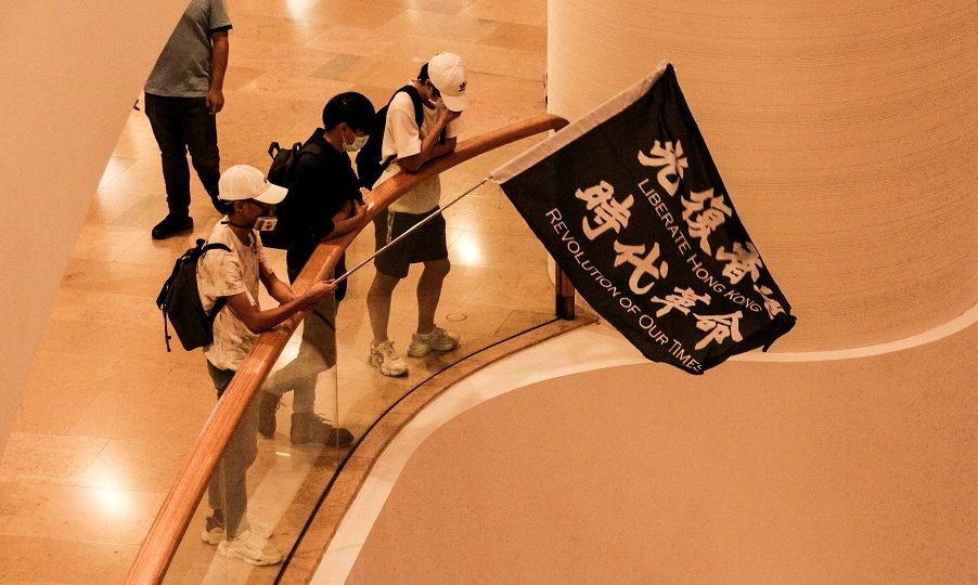 Protesters wave a flag saying “Liberate Hong Kong, revolution of our times” in Pacific Place, a luxury mall in Admiralty. Photo: Tommy Walker