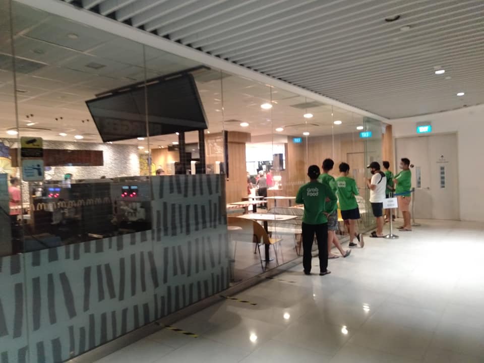 GrabFood deliverymen queue for orders. Photo: Singapore Atrium Sale/Facebook