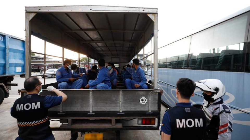 Ministry of Manpower officers question migrant workers in the back of a truck in an undated photo. Photo: Ministry of Manpower/Facebook