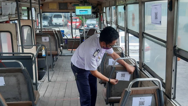 A bus operator places a QR code for check-in via the Thailand Wins tracking system on the back of a passenger seat. Photo: BMTA / Facebook 