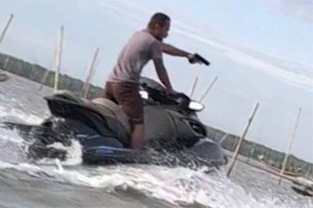 Santi Nualsen captured in a still image riding a jet ski and firing shots.

