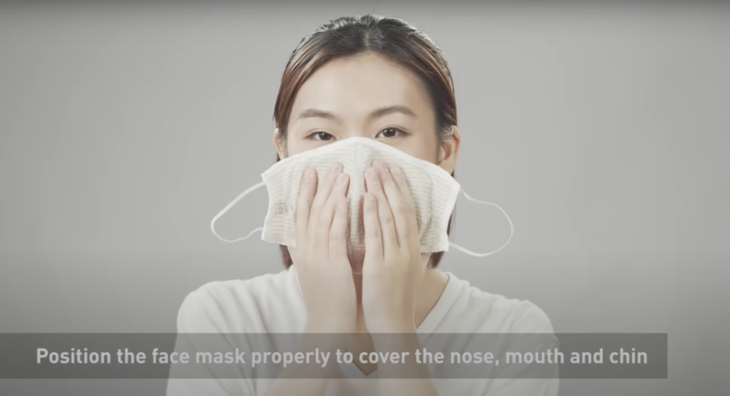 A woman demonstrates how to wear the CuMask+. Photo via YouTube/The Hong Kong Research Institute of Textiles and Apparel