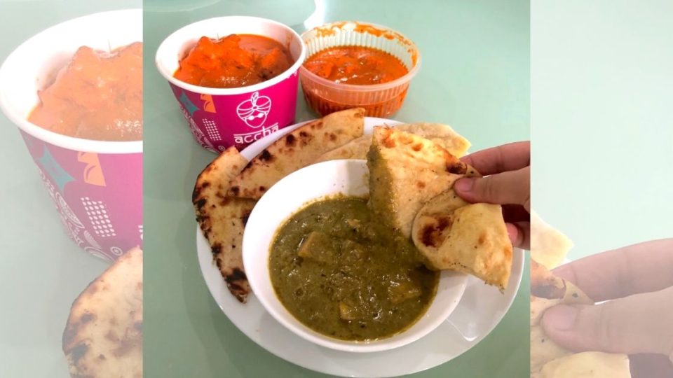 Several dishes from new Indian takeaway chain Accha: Butter Chicken on top of basmati rice (pink bowl), Garlic Naan, and Saag Paneer. Photo: Nadia Hamid for Coconuts Jakarta