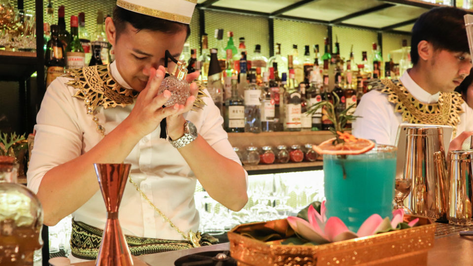 Bar Thewada’s owner Poompat Chinpongpanich recites incantations to bless his ‘holy water’ before sprinkling it atop a cocktail.
