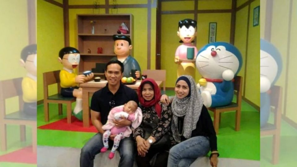 Nurhasanah (center), best known as the Indonesian voice of cartoon character Doraemon, posing with her family in front of a Doraemon diorama. She passed away on Sunday, July 12 at the age of 62. Photo: Instagram/@nurhasanahdora