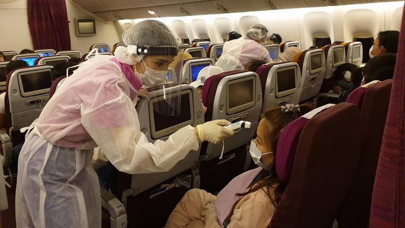 A flight attendant screens a Thai passenger returning from Hong Kong. Thai Airways / Facebook