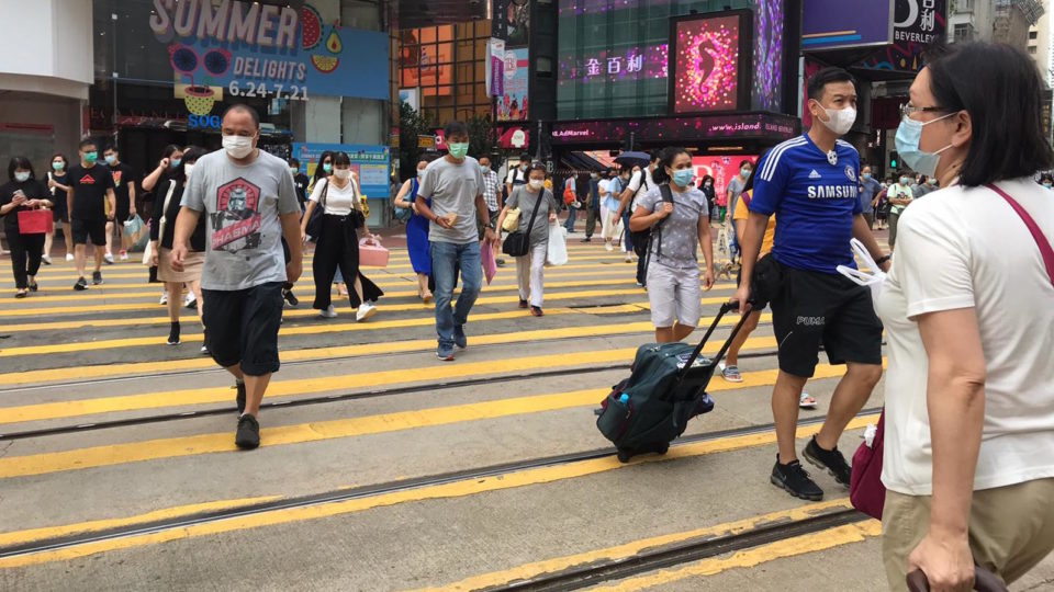 Pedestrians cross the street outside Sogo Department Store in Causeway Bay on July 20, 2020. Photo via Natalie Khoo for Coconuts Media