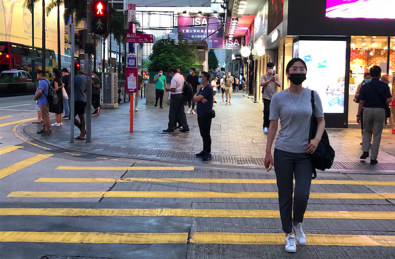 A woman crosses a street in Tsim Sha Tsui on July 22, 2020. Photo via Coconuts Media