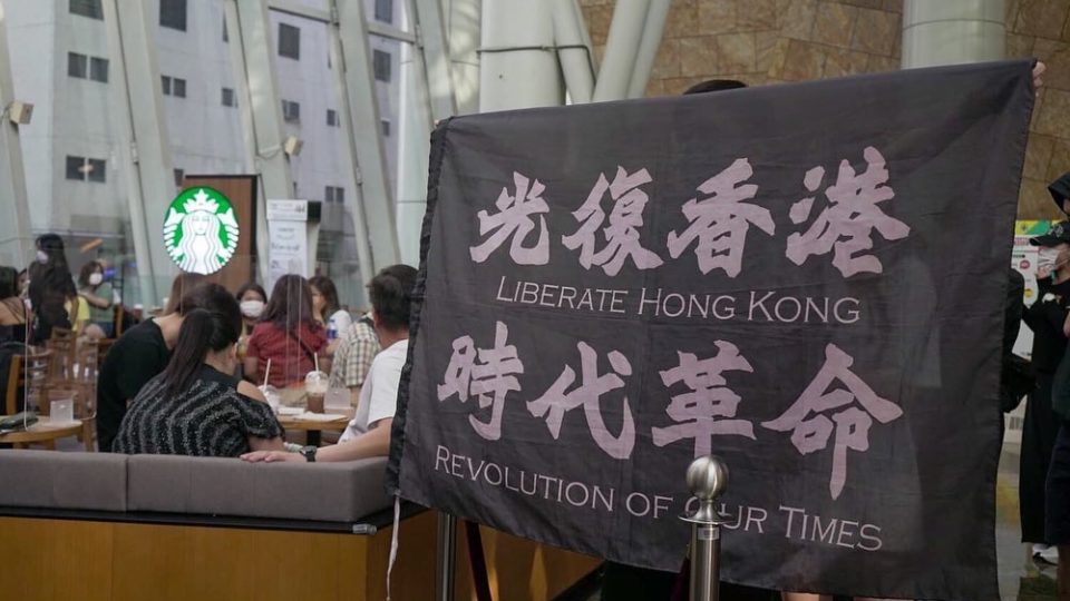 A protester holds up a “Liberate Hong Kong, revolution of our time” flag in Langham Place, Mong Kok. Photo via Facebook/Daily Record