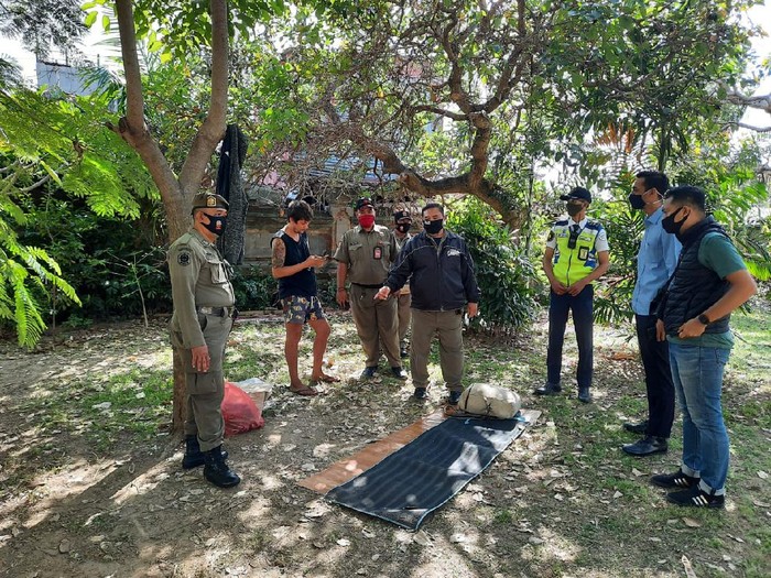 The Russian tourist has reportedly been sleeping near an empty lot right next to the airport for some time. Photo: Istimewa via Detik