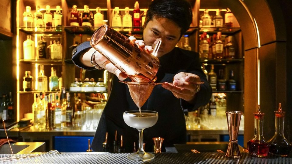 A bartender at Philtration pours a drink. Photo: Chayanit Itthipongmaetee / Coconuts Bangkok