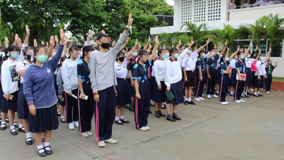 Students at the Yupparaj Wittayalai School in Chiang Mai this morning raise three-finger salutes against dictatorship. Photo: Tanawat Wongchai / Facebook
