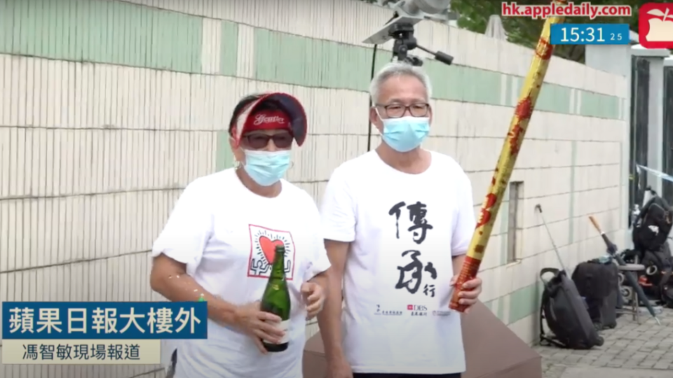 A man and a woman celebrate the arrest of Hong Kong media tycoon Jimmy Lai the Apple Daily office in Tseung Kwan O. Photo via Apple Daily screenshot