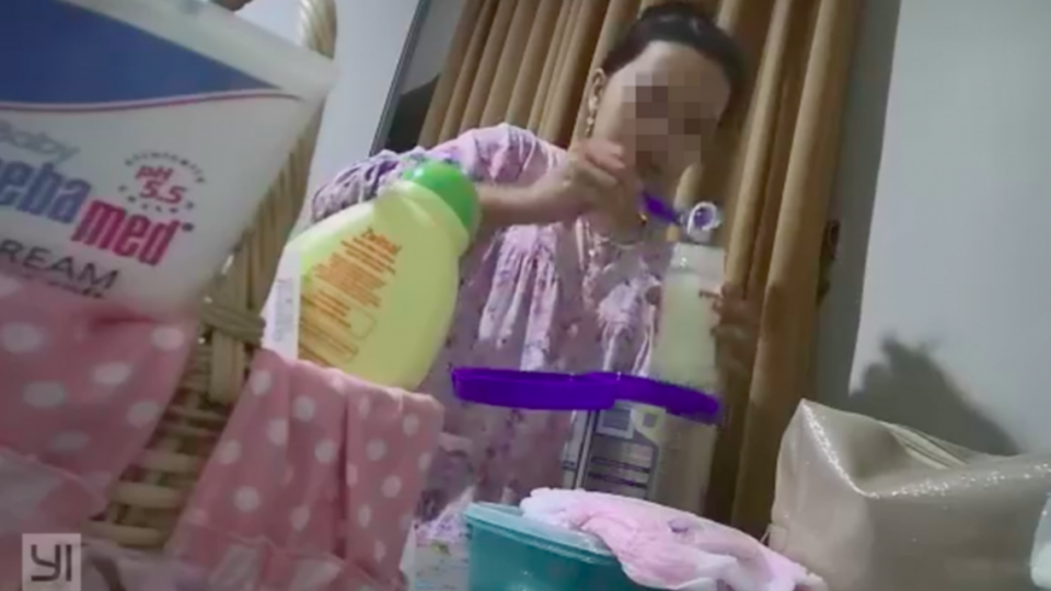 A domestic helper tampers with infant formula milk. Screenshot via Facebook video