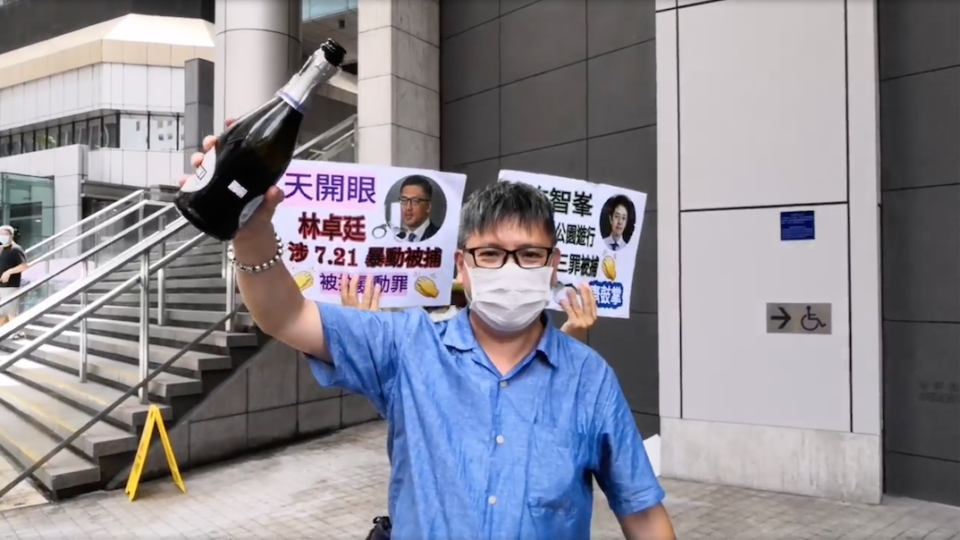 Innes Tang, the chairman of pro-Beijing group Politihk Social Strategic, pops champagne outside the police headquarters in Wan Chai on Aug. 26, 2020. Photo via Facebook/Politihk Social Strategic