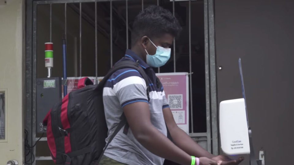 A dormitory resident applying hand sanitizer. Image: Ministry of Manpower