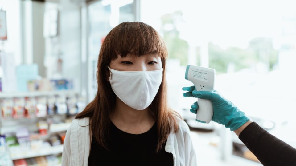 File photo of a woman getting her temperature checked. Photo: Ketut Subiyanto
