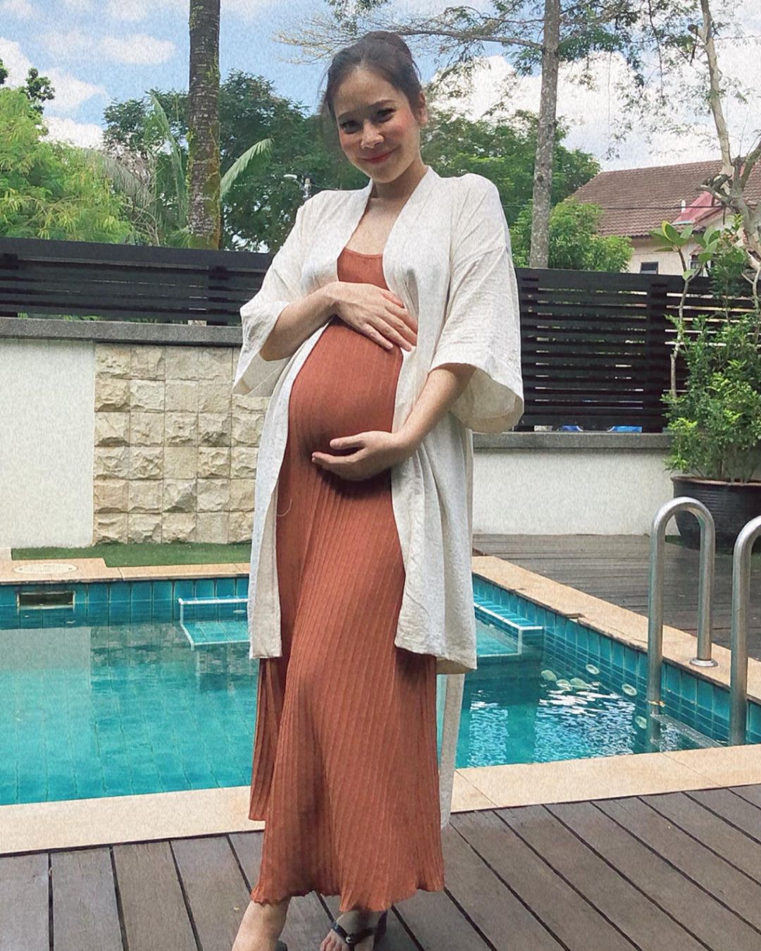 Farrah Nabilah shows off her bump by the pool. Photo: Farah Nabilah /Instagram