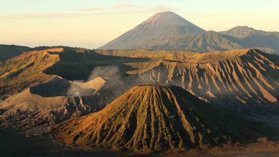 Mount Bromo (large crater, smoking) and Mount Batok with Mount Semeru in the background. Photo: Eveline Tania Mustika/Wikimedia Commons