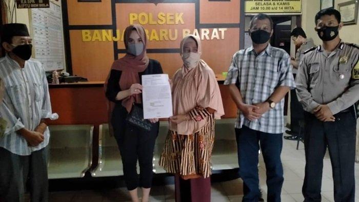 NB (in black blazer) holding up a written apology at the police station. Photo: Banjarbaru Police