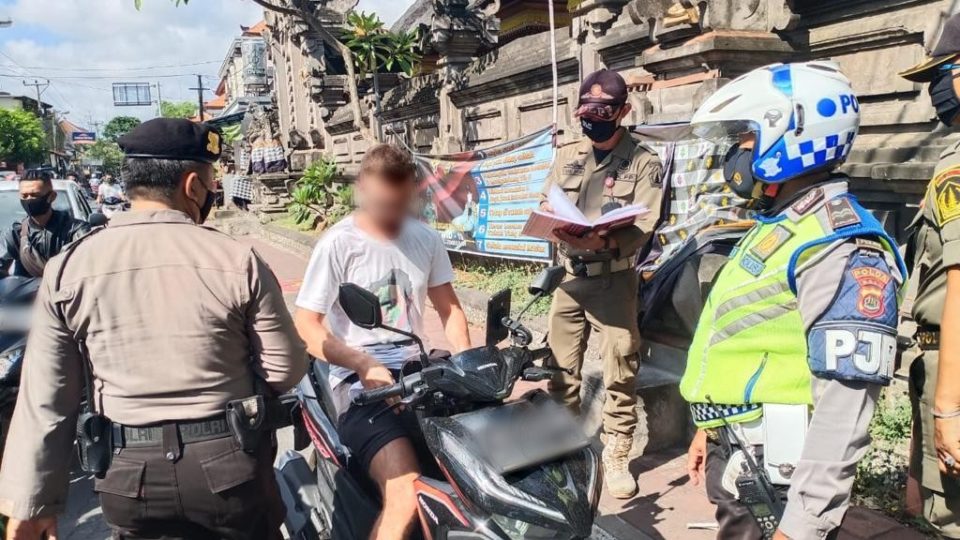 File photo of authorities stopping a foreigner without a mask in Jimbaran in September 2020. Photo: Satpol PP Badung