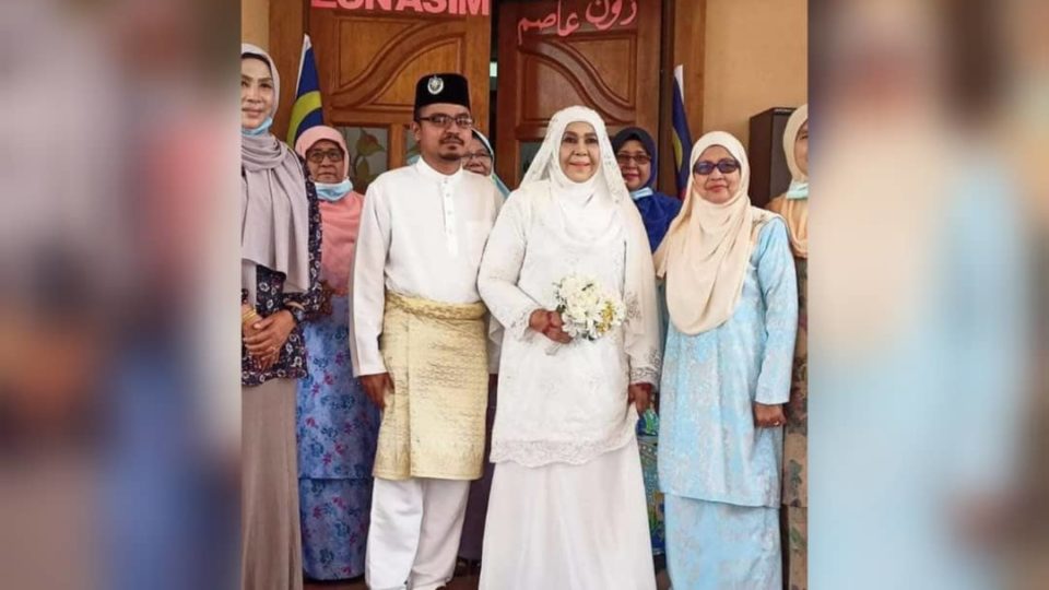 Zaleha Bujang and Muhammad Asyraf (middle, dressed in white) at their wedding ceremony surrounded by family members. Photo: Viral Informasi Malaysiaku /Facebook
