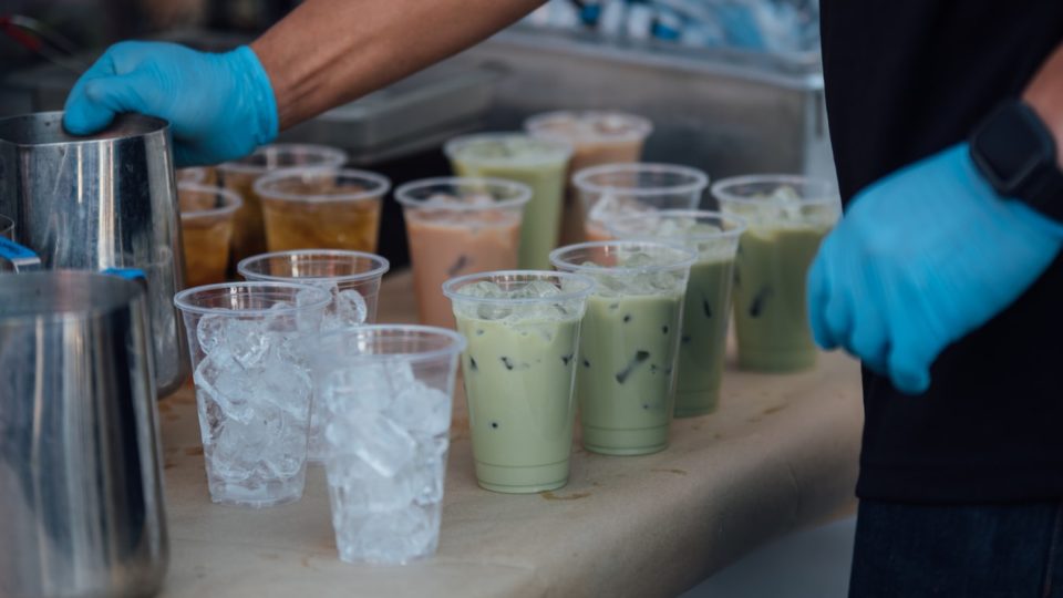 Plastic cups being filled with a beverage. Photo: Frank Zhang
