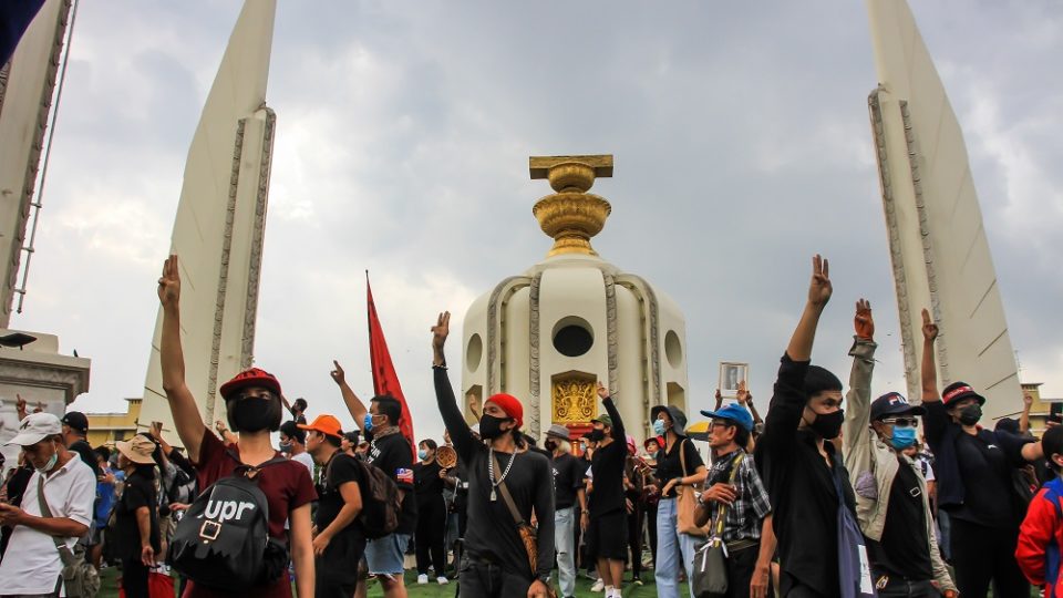 Protesters raise three-finger salutes at the Democracy Monument on Oct. 14, 2020. Photo: Coconuts