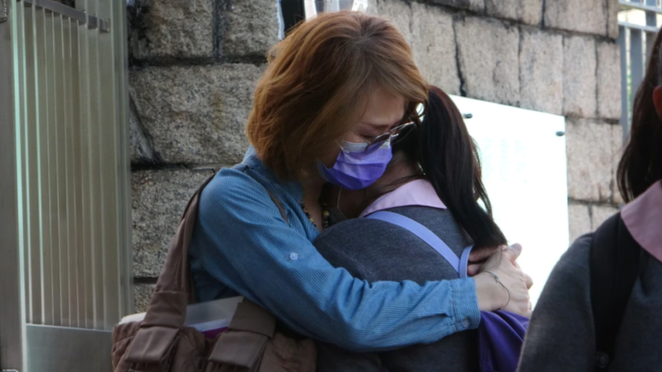 Parents hugged their children outside the Kowloon Tong school on Oct. 15, 2020. Photo via Apple Daily