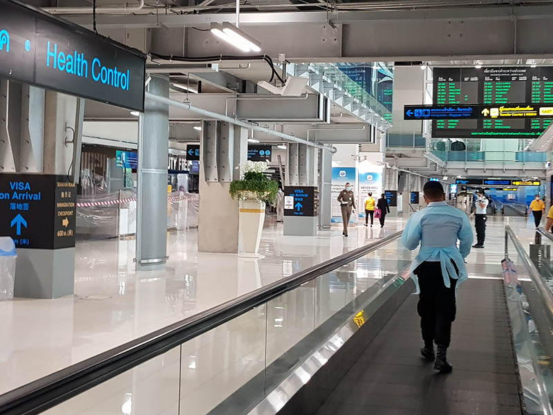 An officer leads arrivals to immigration Sept. 28 at Suvarnabhumi Airport.