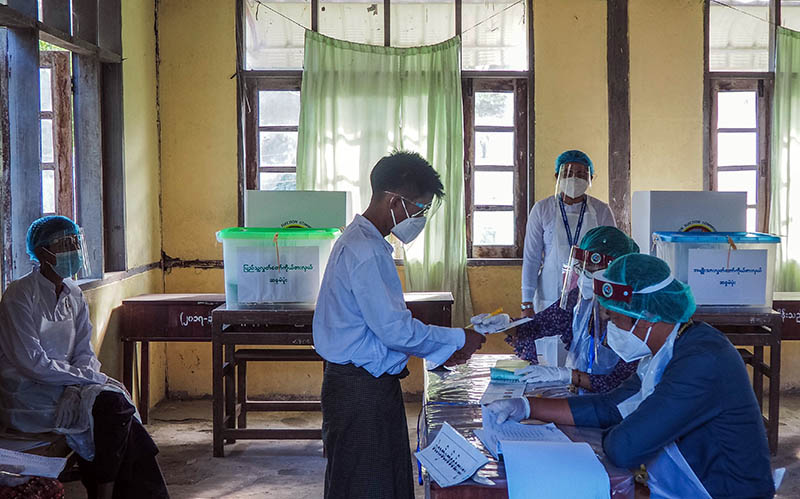 A man receives his ballot on Nov. 8, 2020, at a polling station in Yangon’s Kawhmu Township. Photo: Coconuts