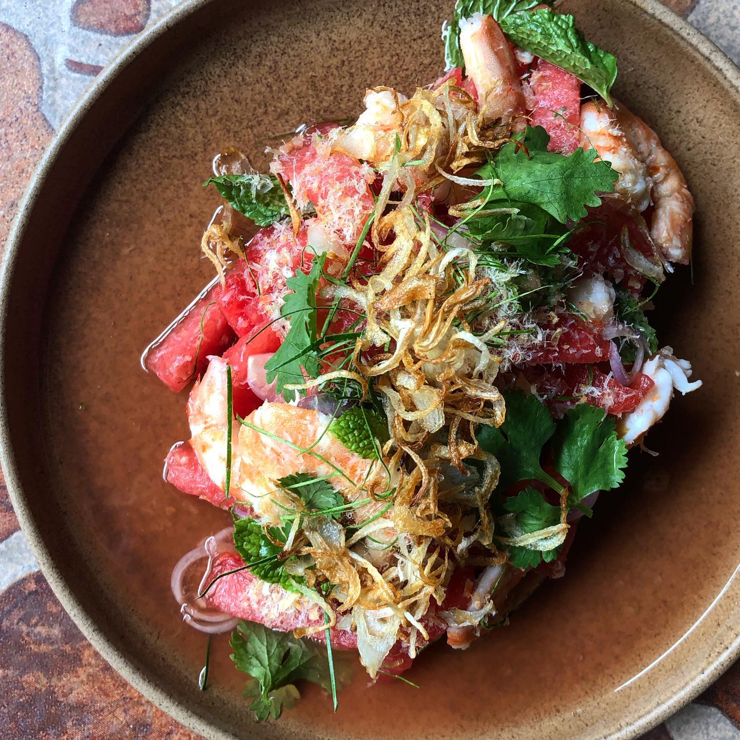 Grilled shrimp and watermelon salad with toasted shrimp powder and fried shallots. 