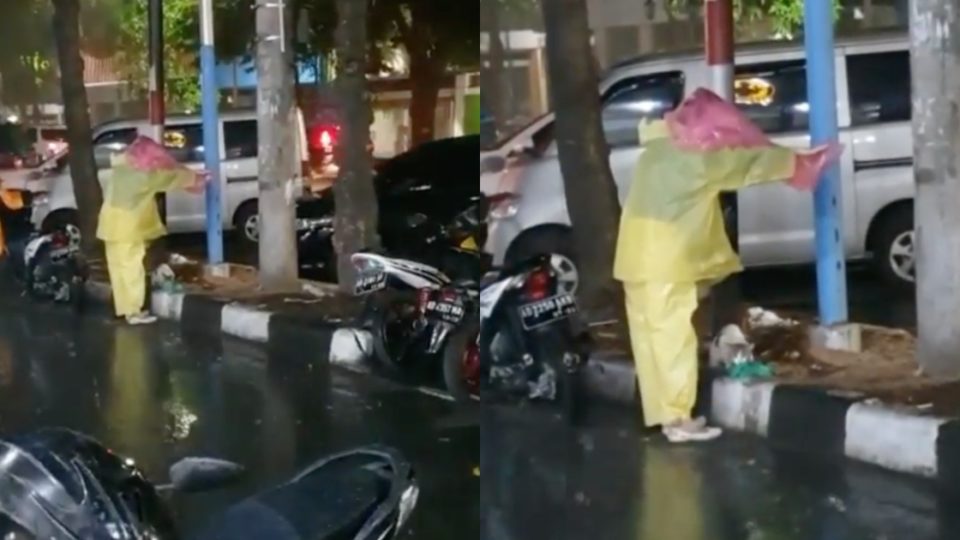 In the video, the woman in the yellow raincoat appears to be holding another raincoat on her head over a grey-white cat, who was enjoying its meal amid the pouring rain. Photo: Instagram/@kulinerdisolo