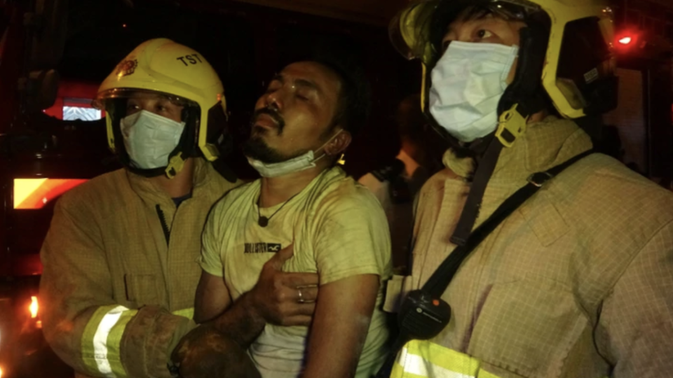 Firefighters escort a victim to safety after flames engulfed the Yau Ma Tei restaurant on Nov. 15, 2020. Photo via Apple Daily