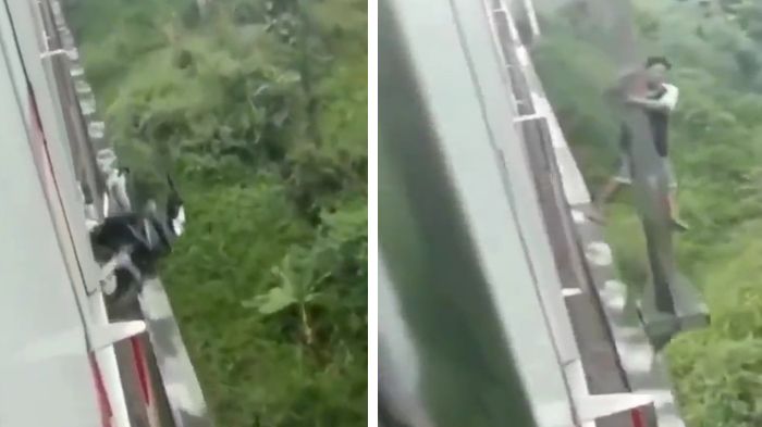 Indonesian man grabbing on to pole on railway bridge as train passes. Photo: Video screengrab
