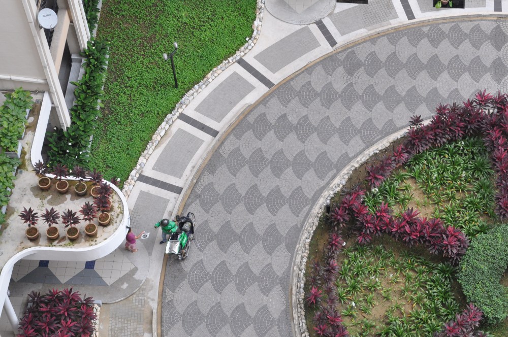 Aerial view of a delivery person, in green, sending food to a customer. Photo: Coconuts