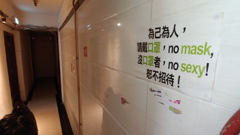 A sign outside one of the many brothels in the Mong Kok building reads “no mask, no sexy.” Photo via Apple Daily