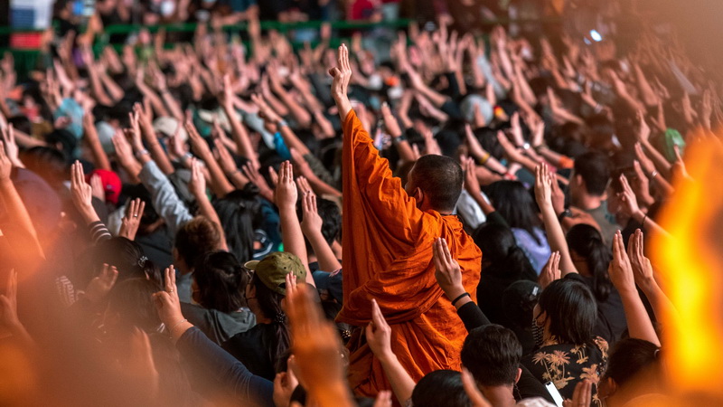 A monk flashes a three-finger salute at an Oct. 18 pro-democracy rally at Asoke Intersection. Photo: Natt Ledger / Courtesy