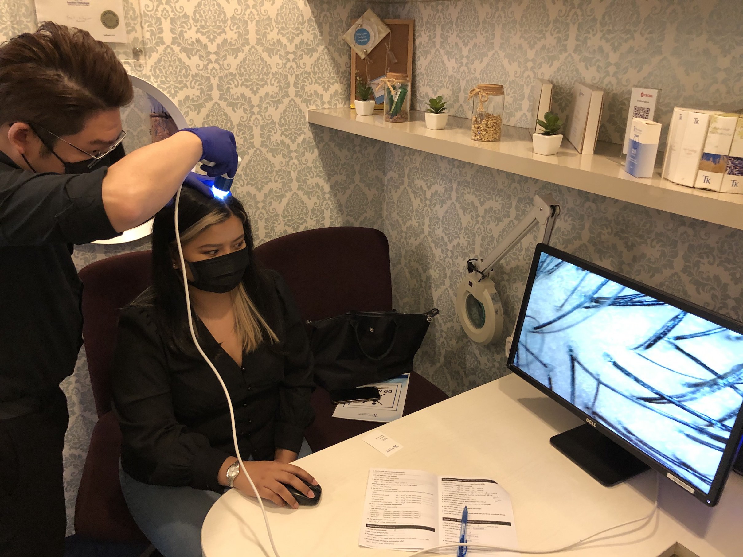 My hair & scalp specialist, Kim, scans my scalp with a magnifying lens. Photo: Coconuts Singapore