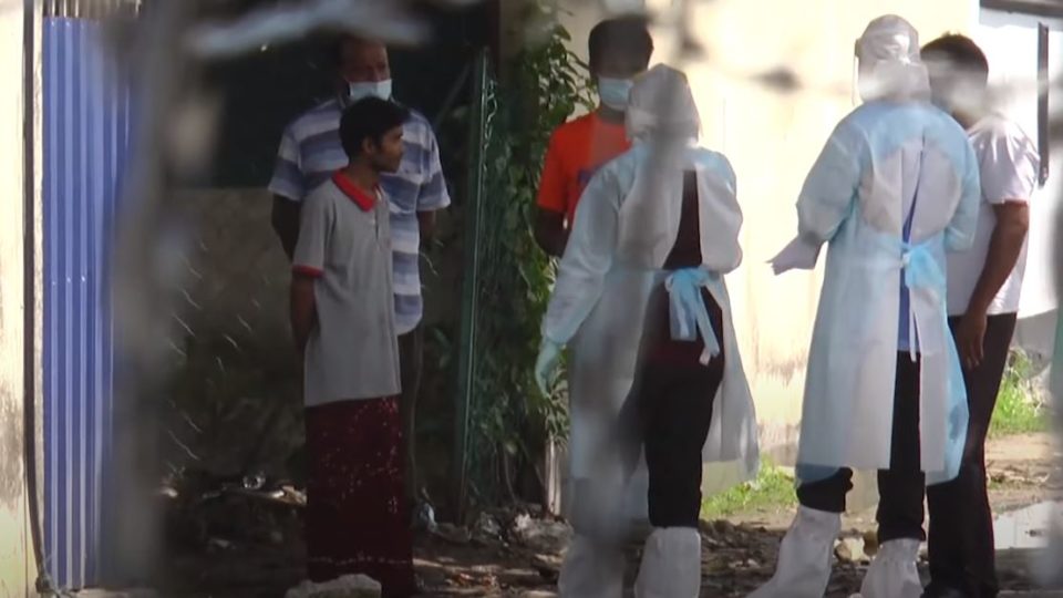 Medical personnel speaking to Top Glove staff in Klang. Photo: National Security Council Malaysia