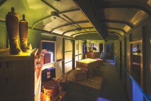 Interior of the Fourgon car showcasing exhibits of clothing and silverware. Photo: Orient Express