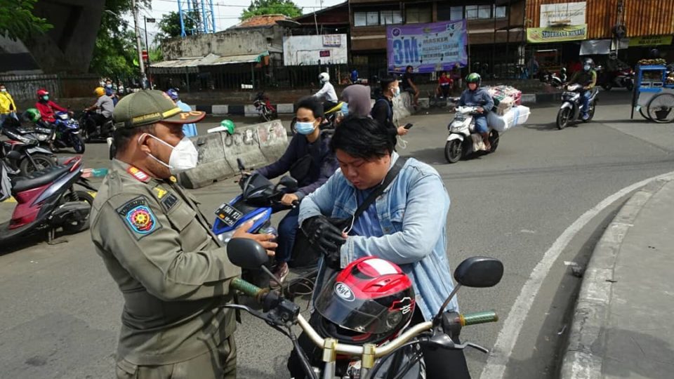 A Public Order Agency officer reminding a motorist to wear a mask. Photo: Twitter/@SatpolPP_Jakpus