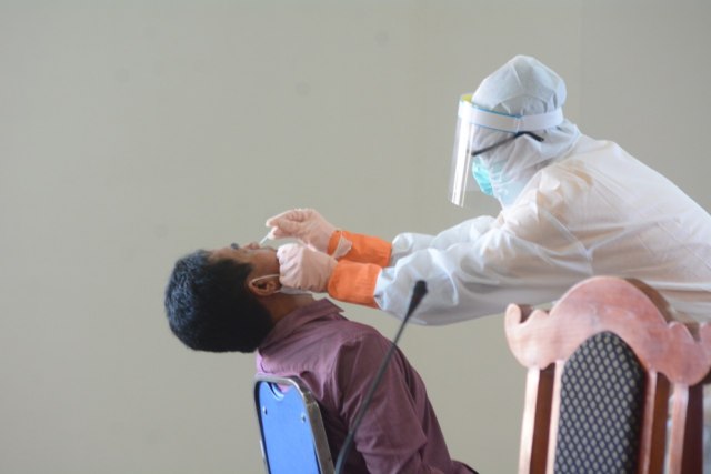 A health worker conducting a swab test. Photo: Istimewa via Kumparan