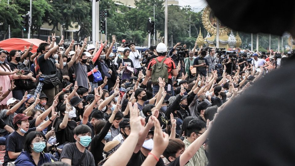 Protesters flash three-finger salutes in defiance of the dictatorship at a November protest in front of the Democracy Monument in Bangkok. Photo: Coconuts
