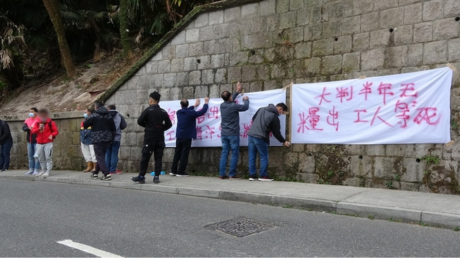 Construction workers hung banners to protest what they say is six months' worth of unpaid wages. Photo via Apple Daily