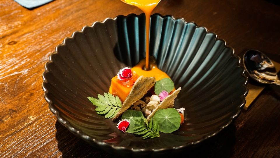 A colorful, eastern adaptation of ‘Kaeng Kradang’ with a thickened, bright orange-hued tomato consomme poured onto jellies made from sake-infused tomatoes and curry paste, deep-fried fish skins and boiled whelks. Photo: Coconuts