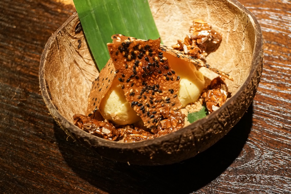 Served in an open coconut shell, pumpkin ice-cream, ginger cookie crumbs, sesame crackers and caramelized wild almonds. Photo: Coconuts